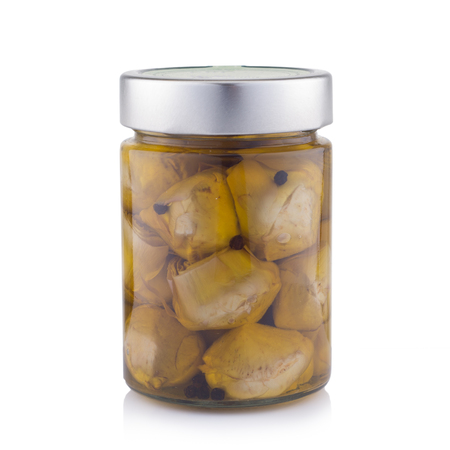 delicious marinated mushrooms in the glass jar isolated on white.の写真素材