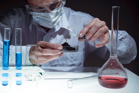 Young man scientist using auto-pipette with flask in medical science laboratory. Researcher concept.の写真素材