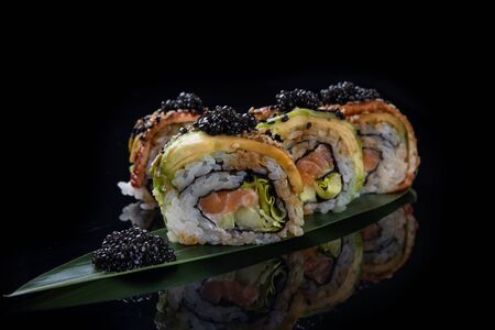 Sushi roll Philadelphia with salmon, smoked eel, avocado, cream cheese on black background. Japanese food.の写真素材
