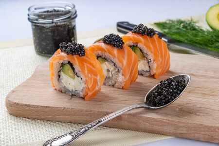 Sushi roll Philadelphia with salmon, smoked eel, avocado, cream cheese on black background. Japanese food.の写真素材