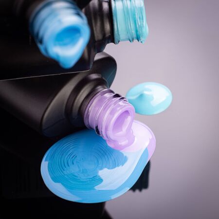 Bottles with spilled nail polish over white backgroundの写真素材