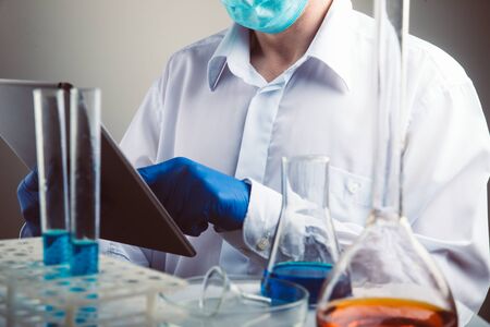 Professional scientist holding a test tube and tablet while making a research.の写真素材
