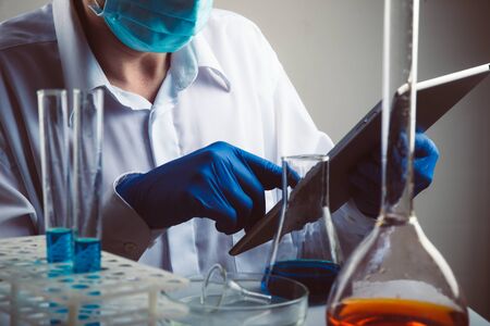 Professional scientist holding a test tube and tablet while making a research.の写真素材