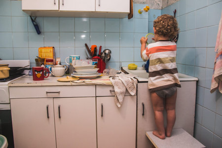 My son plays with dishes in the kitchenの写真素材