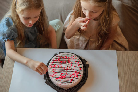 direct children, girls caps without hesitation eat birthday, beautiful cake with their hands at...