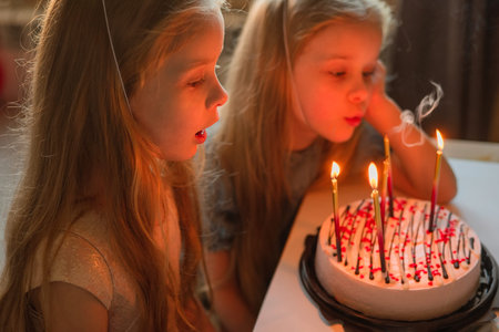 a little girl on her birthday sits on the floor next to scattered confetti from a festive hat. child...