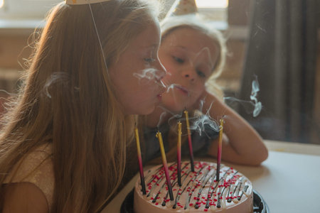 a little girl on her birthday sits on the floor next to scattered confetti from a festive hat. child...