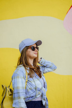 close-up portrait in profile of a young woman outdoors in summer in sunglasses and a baseball cap...