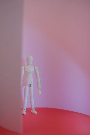 wooden man stands on a red and pink background. high quality photoの写真素材