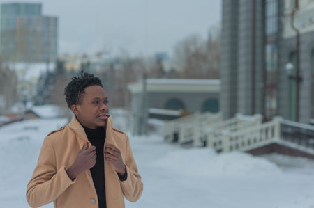 young African American in winter against the backdrop of a majestic building