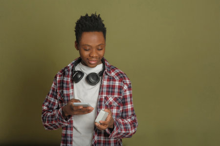 young black guy connects bluetooth speaker to phoneの写真素材