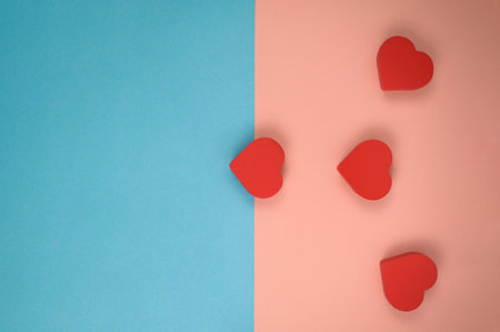 Four red hearts on pink and blue backgroundの写真素材