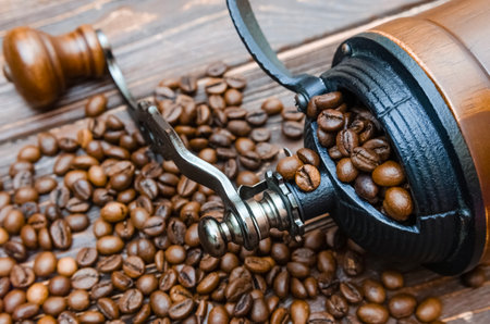 Coffee grinder with coffee beans on a wooden background.の写真素材
