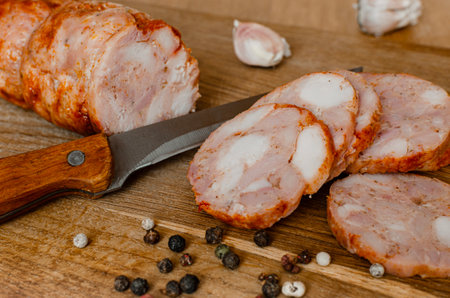 Chicken roll on a chopping board. Chicken sausage. Appetizing meatloaf on a wooden board.の写真素材