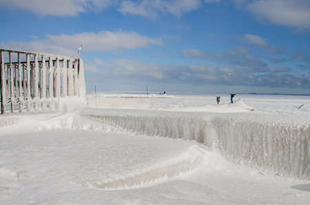 The photo shows a snowy landscape, the ground and structures are covered with thick layers of snow and ice.の写真素材