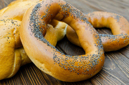 Bagel and breadd with poppy seeds on a wooden backgroundの写真素材