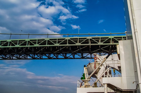 A large cargo ship passing under the bridge, photograph taken from the deck of the ship.