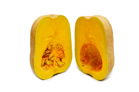 A fresh butternut squash cut in half, revealing its vibrant orange flesh and seeds, isolated on a clean white backgroundの写真素材