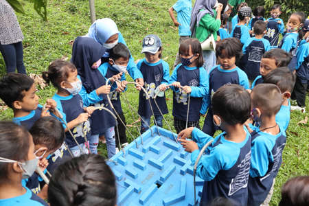 bogor, indonesia - 09 july 2021 : outdoor activities for preschool children during the covid-19 pandemic, having fun playing and feeding deer on 06 july 2021 in bogorのeditorial素材