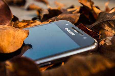 bogor,indonesia - 07 july 2021 : samsung mobile on a pile of dry leaves with morning lightのeditorial素材