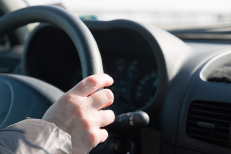 Womans hand on steering wheel of car. Driving woman.の写真素材