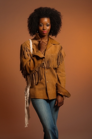 Vintage seventies fashion african woman with brown leather jacket. Brown background.の写真素材