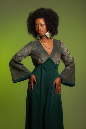 Sensual retro seventies fashion afro woman with green dress. Green background.の写真素材