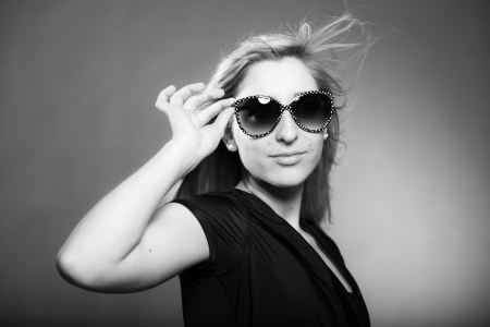 Beauty portrait of pretty girl with long blonde hair and sunglasses. Black and white shot.の写真素材