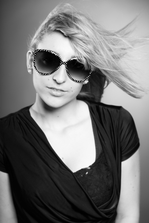 Beauty portrait of pretty girl with long blonde hair and sunglasses. Black and white shot.の写真素材