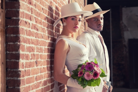 Vintage fashion romantic wedding couple in old urban building. Mixed race.の写真素材