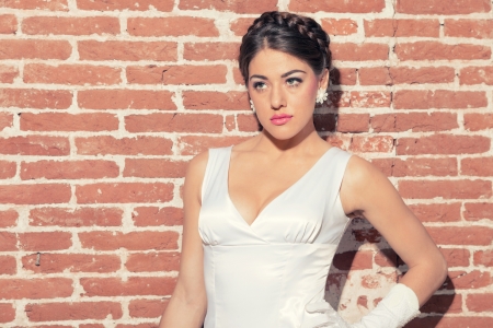 Vintage romantic sensual bride against old brick wall. Urban environment.の写真素材