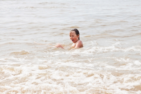 One young boy playing in the ocean with waves.の写真素材
