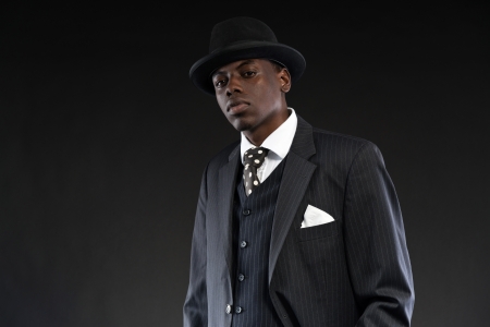 Retro african american gangster wearing striped suit and tie and black hat. Studio shot.の写真素材