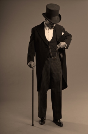 Retro afro american dickens scrooge man with mustache  Wearing black hat  Holding a vintage timepiece の写真素材