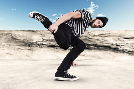 Street dancing man urban fashion with beard. Wearing black woolen hat. Concrete environment.
