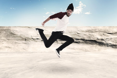 Street dancing man urban fashion with beard. Wearing black woolen hat. Concrete environment.