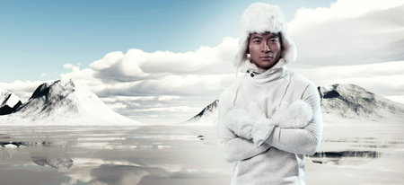 Asian winter fashion man in snow mountain landscape. Wearing white hoody sweater with furry hat and...