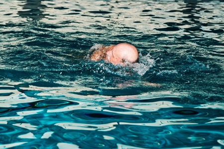 Healthy senior man with beard in indoor swimming pool.の写真素材