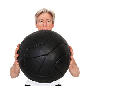 Senior fitness man exercising with black wall ball. Isolated on white.の写真素材