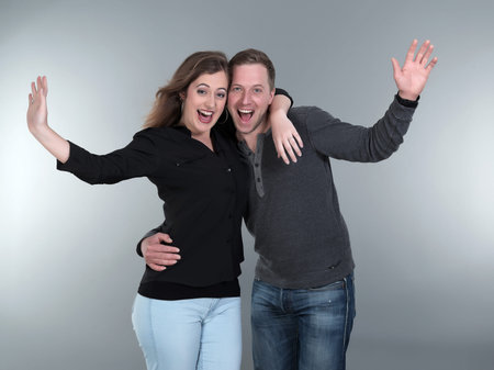 Casual fashion romantic happy couple. Young man and woman. Studio shot against grey.の写真素材