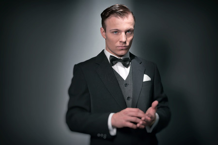 Retro 1920 business fashion man wearing black suit and bow tie. Studio shot.の写真素材