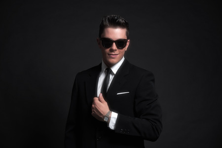 Retro fifties fashion man wearing black sunglasses with suit and tie. Studio shot.の写真素材