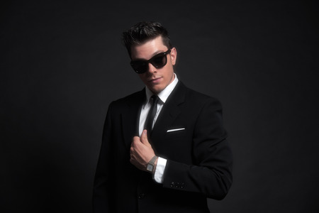 Retro fifties fashion man wearing black sunglasses with suit and tie. Studio shot.の写真素材