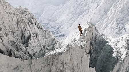 Aerial perspective of hiker standing on peak in snow mountain landscape.の写真素材