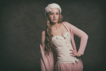 Vintage fashion woman wearing pink corset with dress and white hat. Studio shot.の写真素材