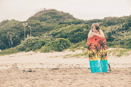 Teenage boy with blonde hair on the beach with bodyboard. Gonubie. Eastern Cape. South Africa.の写真素材