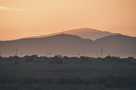 Truck driving through mountain semi desert landscape at sunrise. Swartberg. Western Cape. South Africa.の写真素材
