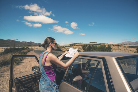 Woman standing next to old car reading a map. Swartberg. Western Cape. South Africa.の写真素材