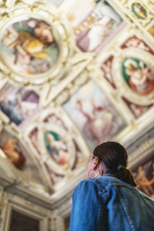 Female brunette tourist looking at ceiling of church in the Vatican.の写真素材