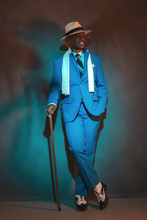 African american dandy man in blue suit and straw hat. Holding cane.